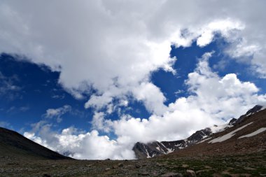 Beautiful white clouds,blue sky.Caucasus mountains clipart