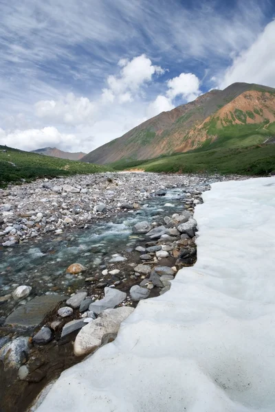 Schönes Eis auf Gebirgsfluss, Tal, Himmel, Wolken. — Stockfoto