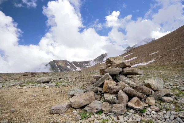 Montón (pirámide) de piedras, montañas del Cáucaso, nubes —  Fotos de Stock