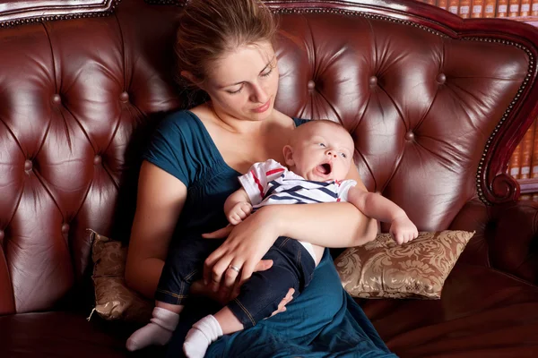 Anya gyermekével, tátongó, kanapé — Stock Fotó
