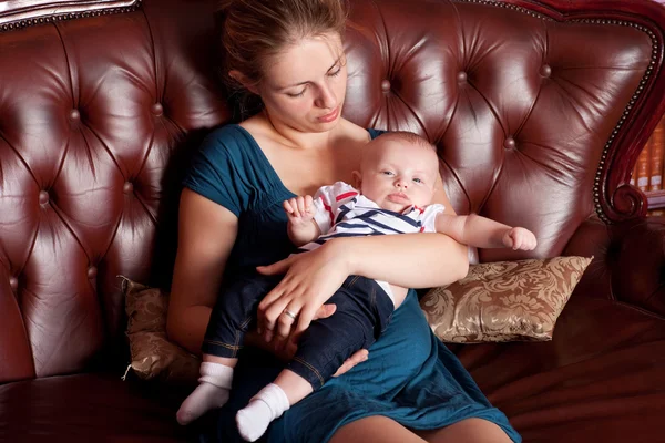 Moeder met haar baby op sofa — Stockfoto