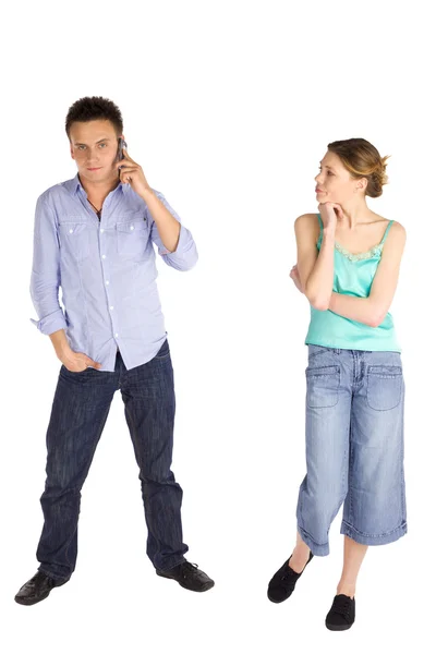 若い魅力的なカジュアルなカップル 男性は電話で話して見ている彼は 白い背景で隔離の女性の心配 — ストック写真