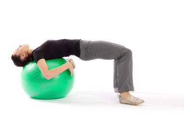 Young fit woman with gym ball doing pilates exercise, isolated on white background. clipart