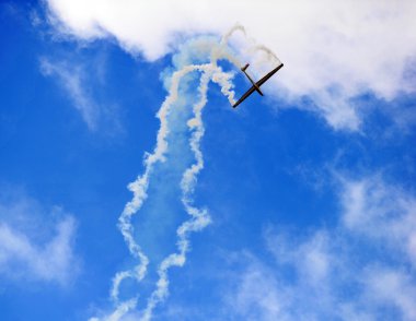 Airplane high in the sky with trailing smoke. clipart