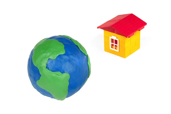 粘土とおもちゃの家の白い背景の上で作られた地球の地球儀 — ストック写真