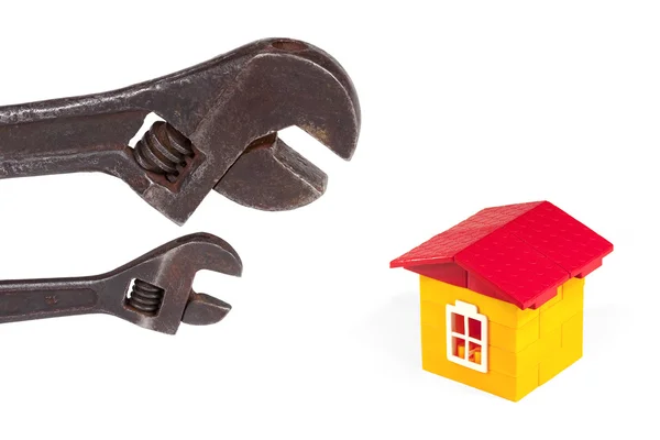 stock image Two old wrench and a toy house with a white background