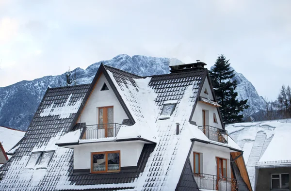 Casa en la nieve con montaña como telón de fondo — Foto de Stock