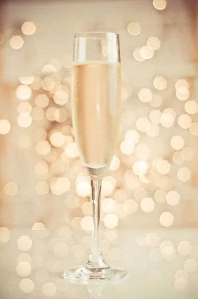 Glas champagne tegen gouden achtergrond — Stockfoto
