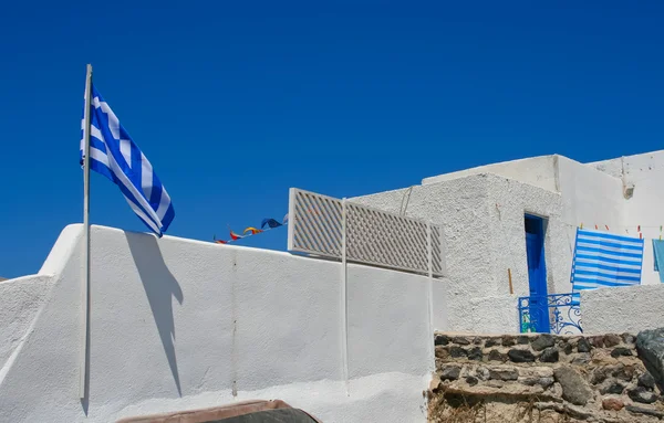 White old street in Santorini with Greece flag — Stock Photo, Image