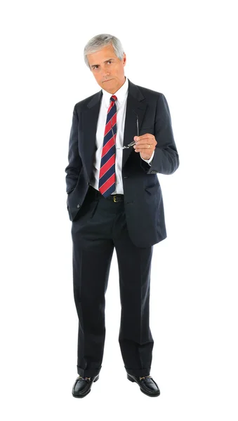 真剣な中年のビジネスマンのスーツとネクタイを片手でポケットに立って 反対側の手に彼の眼鏡を指している 白い背中の上に全長 — ストック写真
