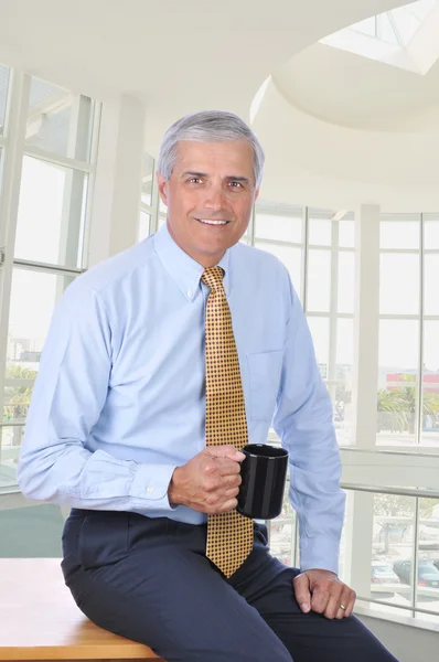 Businessman Sitting on Desk With Coffee — Stock Photo, Image