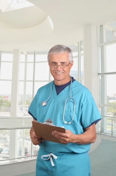 Smiling Middle Aged Doctor Scrubs Holding Patients Cart His Clipboard — Stock Photo, Image