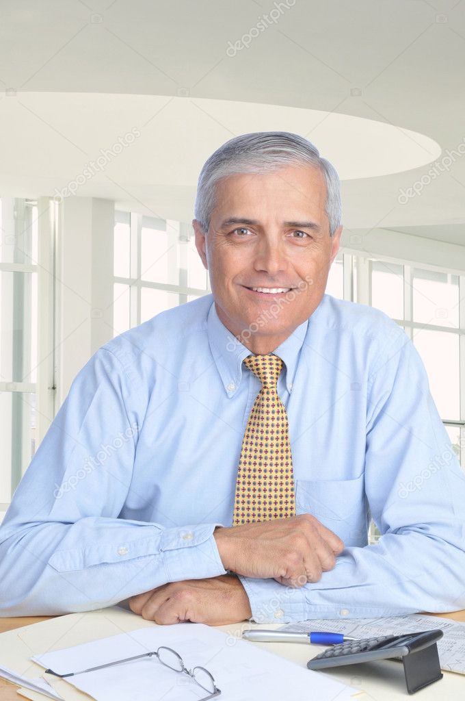 Middle Aged Businessman Seated at His Desk