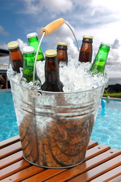 Cubo de cerveza en la mesa de teca junto a la piscina — Foto de Stock
