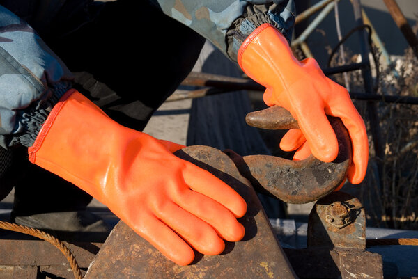 Closeup of worker man at orange gloves