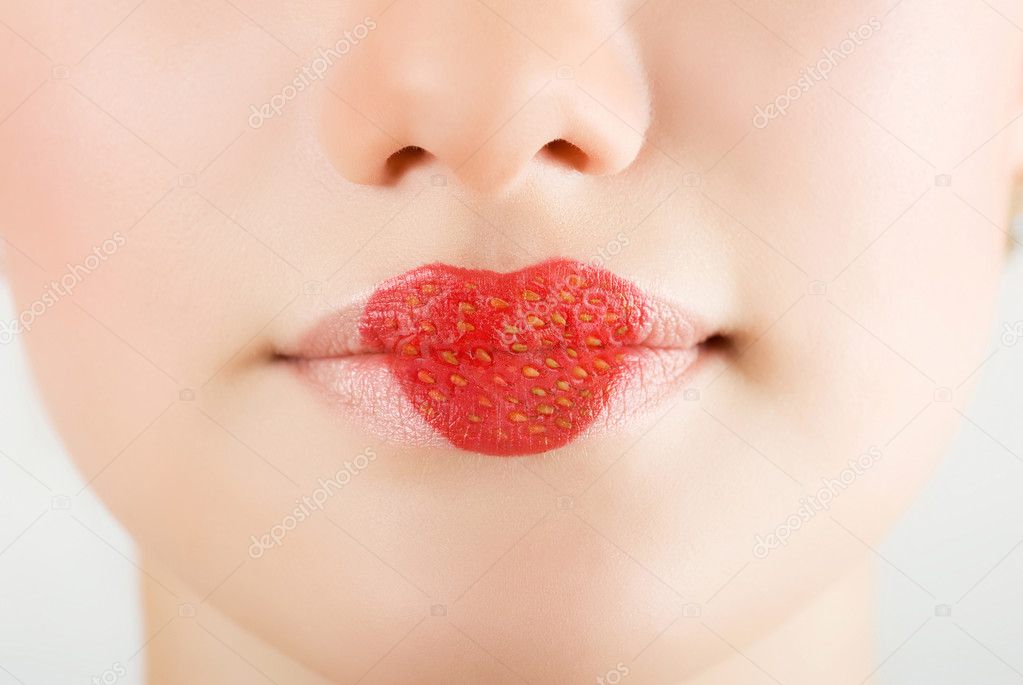 Heart on stawberry lips of pretty woman closeup