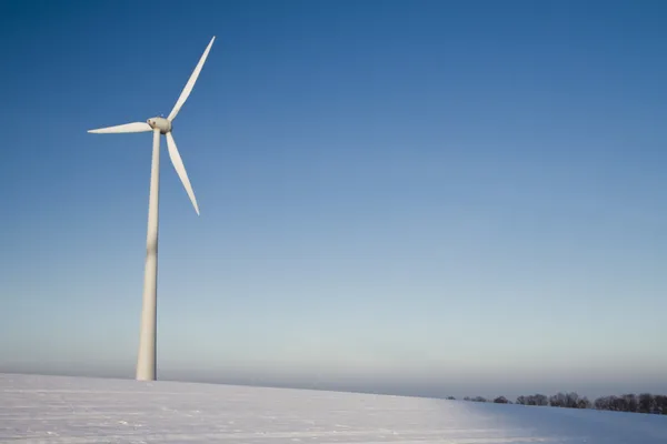 stock image Windmill on a blue sky in winter, alternative energy source