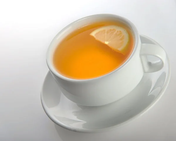 灰色の背景にレモンとお茶のカップ — ストック写真