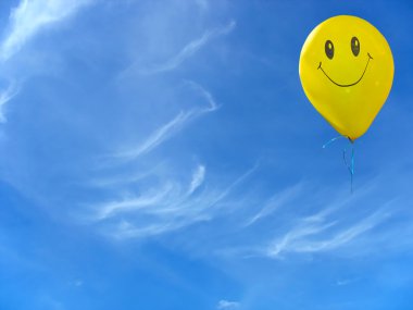 Sarı balon üzerinde bulutlu mavi gökyüzü gülümsemek