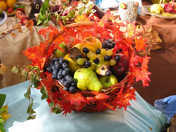 Frutas frescas maduras y hojas de otoño en una canasta de mimbre —  Fotos de Stock