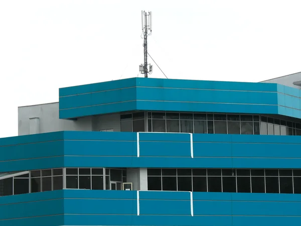 Edifício moderno com antena de comunicação celular — Fotografia de Stock