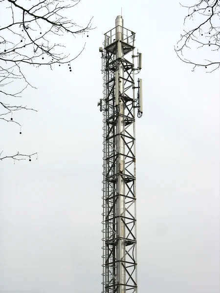 Metalliska meddelande tornet med antenner över himmel bakgrund — Stockfoto