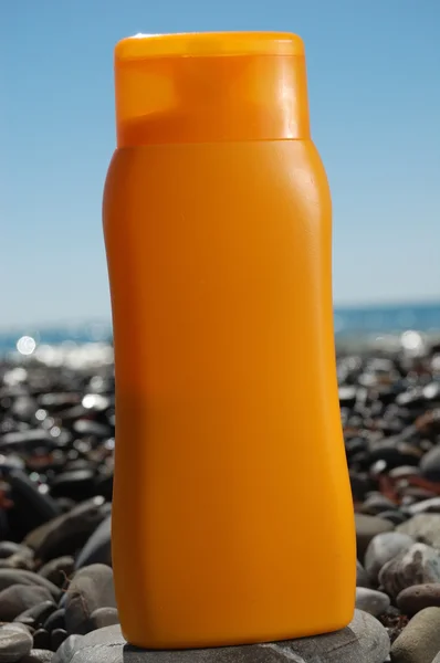 Schlauch mit Sonnenschutz am Strand des Ozeans — Stockfoto