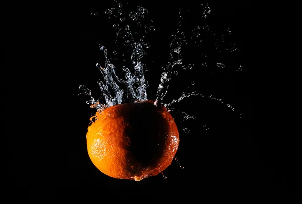 Πορτοκαλί με splash water επάνω σε μαύρο υπόβαθρο — Φωτογραφία Αρχείου