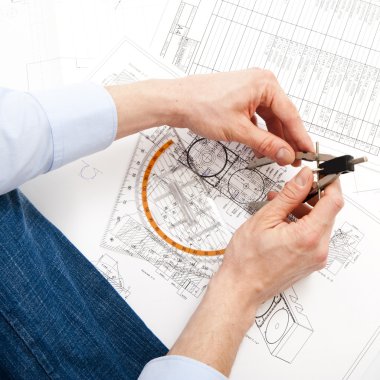 An engineer checking a technical drawing with a pair of compasses and a triangle clipart