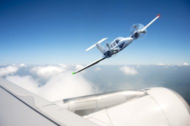 Small aircraft undertaking an evasive maneuver, avoiding collision with a commercial airliner clipart