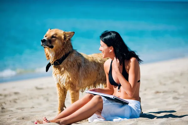 Schöne junge Frau und Hund am Strand — Stockfoto