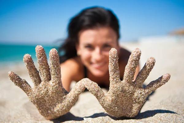 Bir kız elini kuma gösterir. — Stok fotoğraf