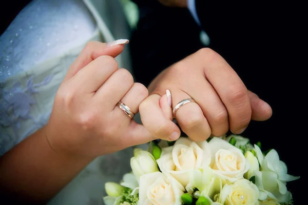 Τα χέρια με δαχτυλίδια και γαμήλια ανθοδέσμη — Φωτογραφία Αρχείου