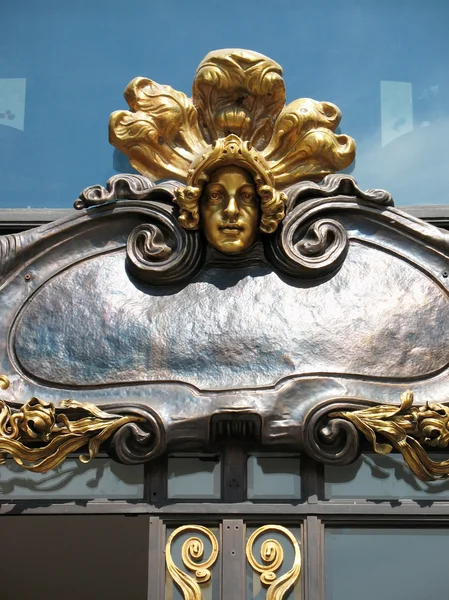 Bronze sculpture on the facade of the House Books - the former building of — Stock Photo, Image