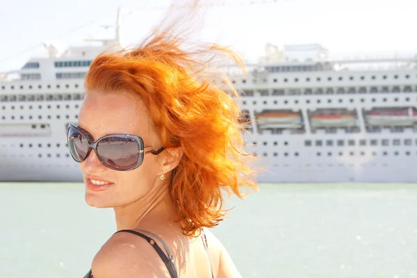 Lachende vrouw en cruiseschip op achtergrond — Stockfoto