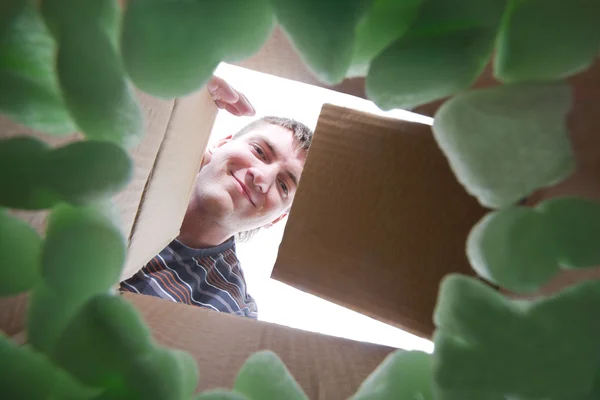 Человек, открывающий картонную коробку — стоковое фото