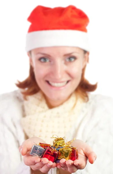 Happy smiling woman in christmas hat with small gifts — Stock Photo, Image