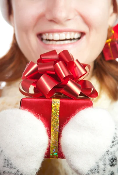 Счастливая улыбающаяся женщина в рождественской шляпе и рукавицах с подарком — стоковое фото