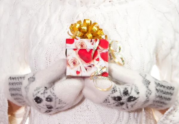 De gift van Kerstmis met boog in de palmen van de handen — Stockfoto