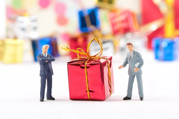Beeldjes van twee businessmans met de gift van Kerstmis — Stockfoto