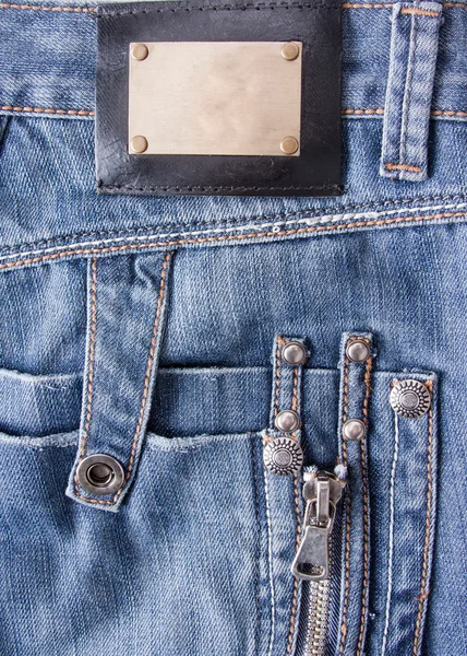 Modré džíny s bronzovou jmenovkou — Stock fotografie