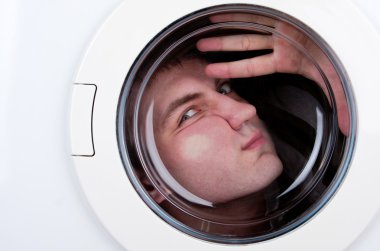 Close-up of bizarre man inside washing machine clipart