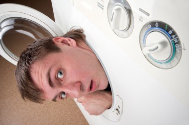 Close-up of surprised man inside washing machine clipart