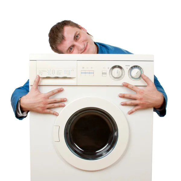 Reparatör omfamnar tvättmaskin — Stockfoto