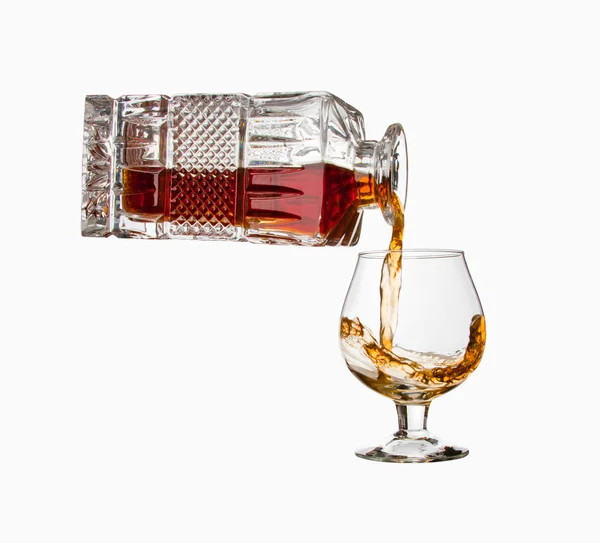 Gieten Cognac Uit Fles Een Glas Geïsoleerd — Stockfoto