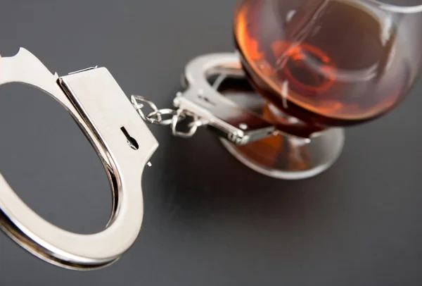 Nahaufnahme Von Handschellen Schloss Mit Glas Alkohol Hintergrund — Stockfoto