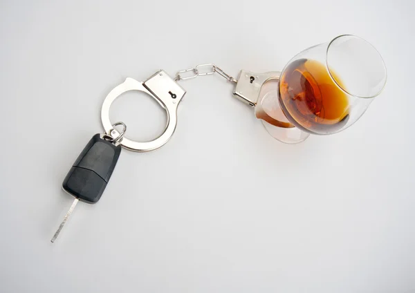 Klíč od auta zamčené na sklenici alkoholu — Stock fotografie