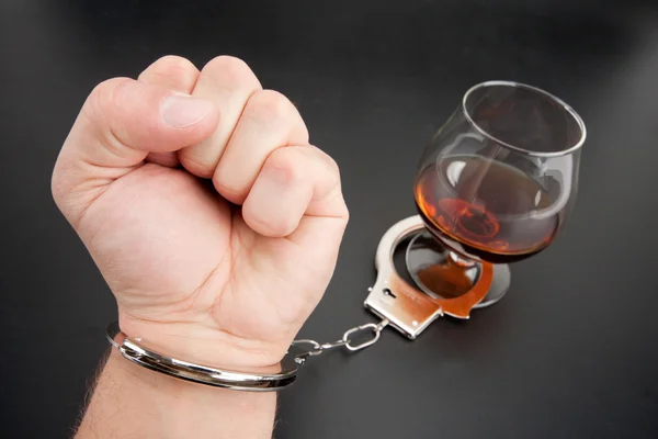 Uma mão trancada no copo de álcool — Fotografia de Stock
