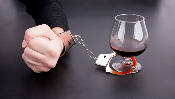 Hand locked to glass of alcohol — Stock Photo, Image