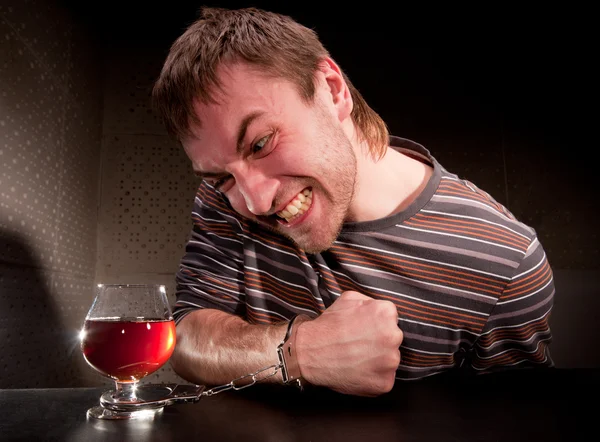 Alkoholik uzamčena na sklenici alkoholu — Stock fotografie